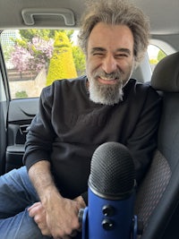 a man sitting in a car with a microphone